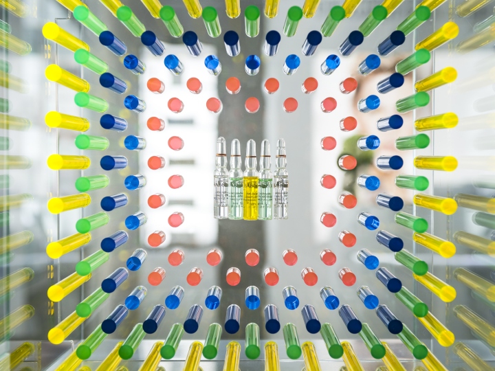 Symmetrisches Babor-Ampullen-Display mit kreisförmiger Anordnung bunter Röhren.